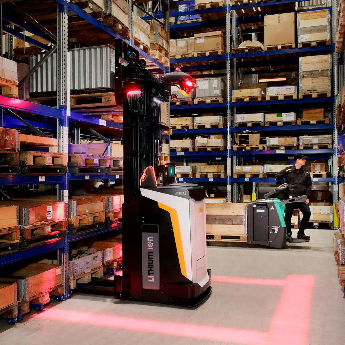 Rocla-lithium-ion-truck fra Logisnext Denmark med sikkerhedsprojektion i lager, medarbejder betjener palleløfter