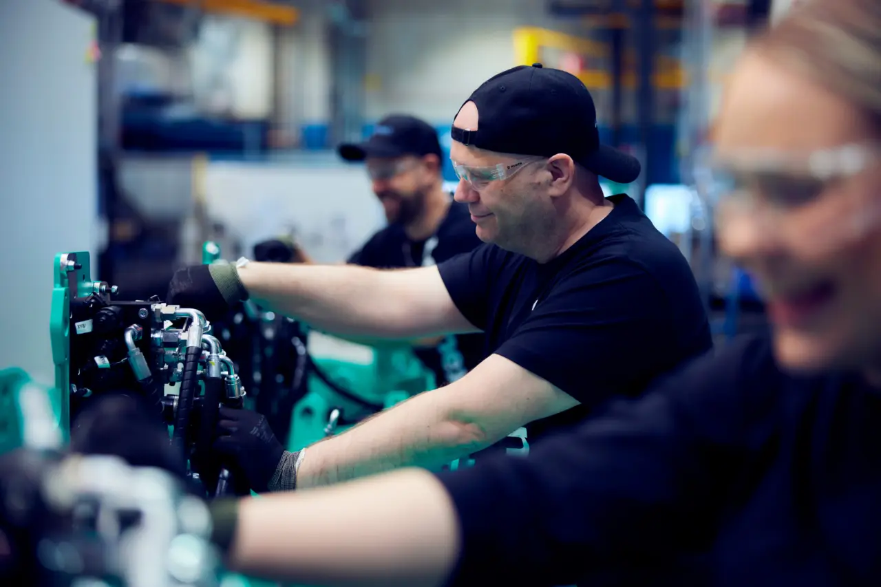 Produktionsmedarbejdere fra Logisnext Denmark samler hydraulikkomponenter på fabrikslinje