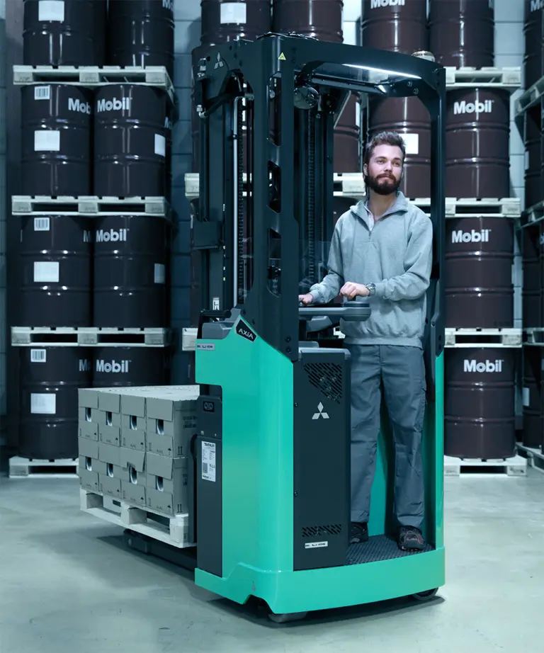 Medarbejder kører AXIA-reachtruck fra Logisnext Denmark med palle mellem Mobil-olietønder