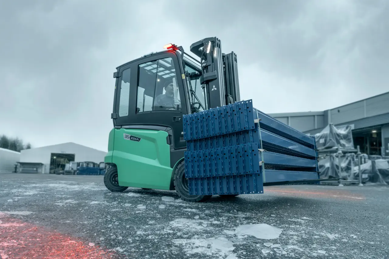 EDiA-gaffeltruck fra Logisnext Denmark transporterer reolsektioner udendørs i vinterlys