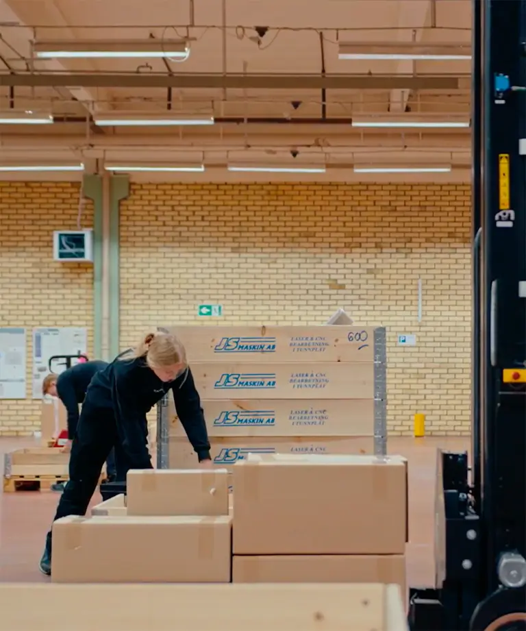 Medarbejdere pakker gods ved AGV-truck fra Logisnext Denmark i produktionslokale