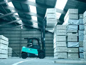 Gaffeltruck fra Logisnext Denmark løfter tømmerpakke højt i træindustrilager