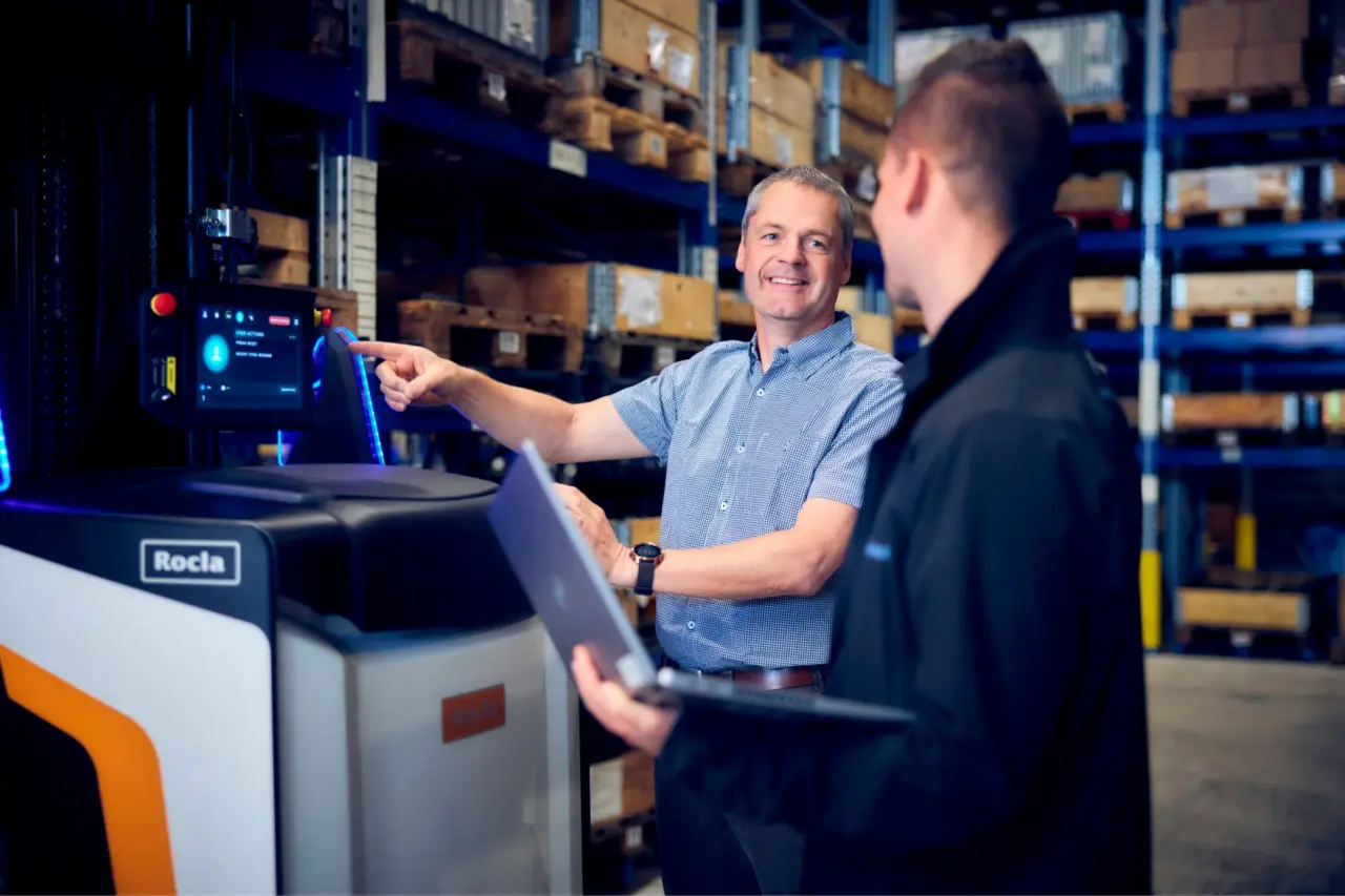 Konsulenter fra Logisnext Denmark konfigurerer Rocla AGV-truck med bærbar computer i lager