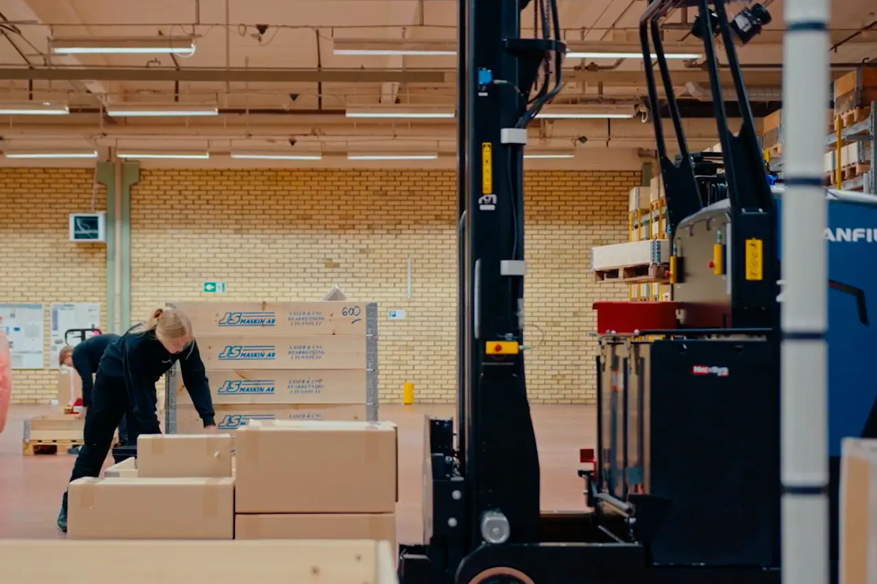 Medarbejdere pakker gods ved AGV-truck fra Logisnext Denmark i produktionslokale